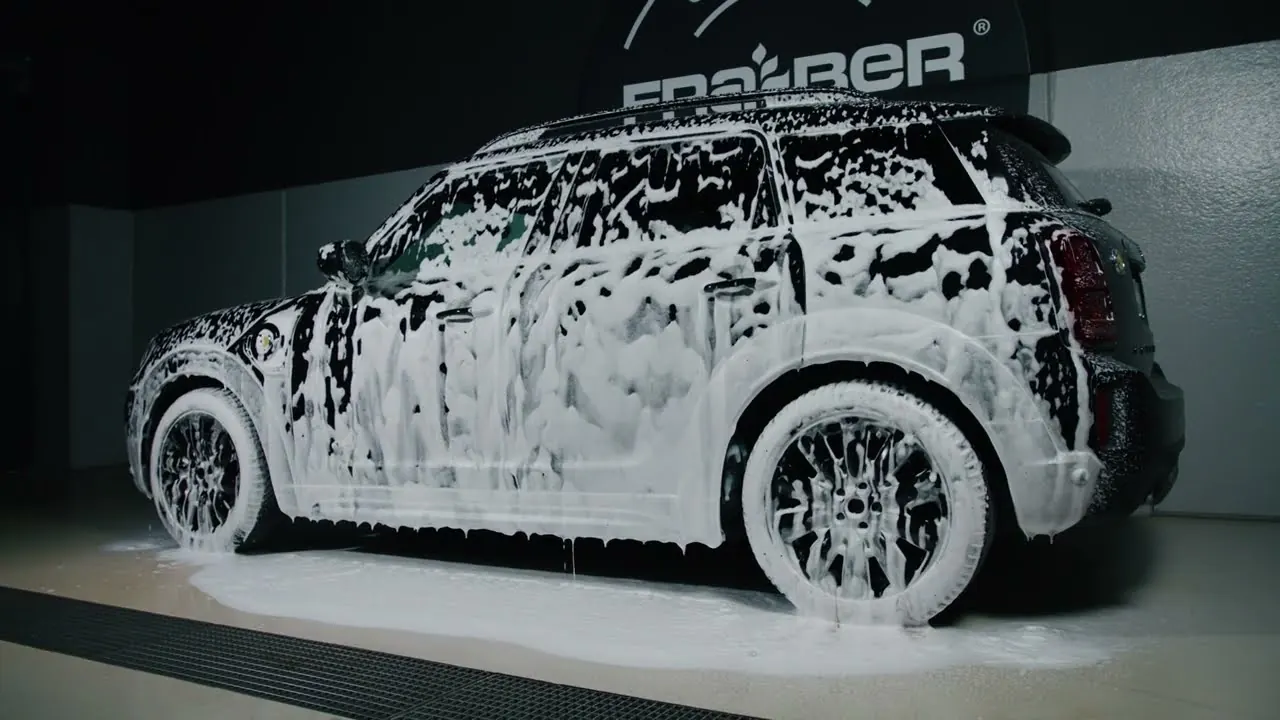 Still from the official Fra-Ber video: a car covered in Neve active foam at the brand’s wash bay